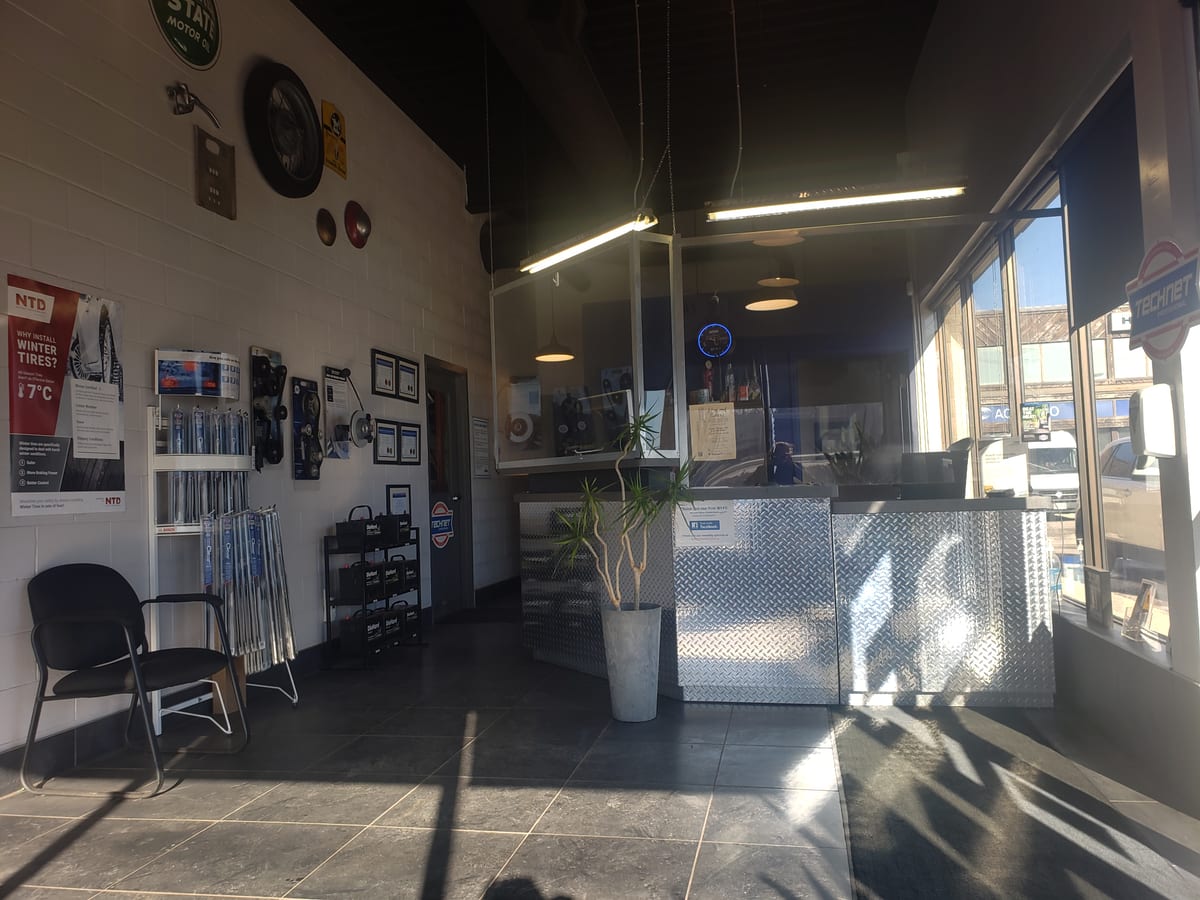 The front office and waiting area in afternoon sun, a chair by the wiper and battery displays